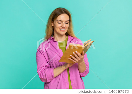 Woman reading book with focused expression flipping pages calmly showing interest and concentration Woman reading book with focused expression flipping pages calmly showing interest and concentration 140367973