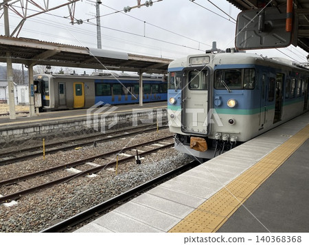 A 115 series train in the new Nagano livery and a JR East Koumi Line KiHa E200 series train lined up at Shinano Railway Komoro Station. 140368368