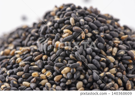 白色背景上的一堆黑芝麻——一種富含芝麻素的健康食品。 白色背景上的一堆黑芝麻——一種富含芝麻素的健康食品。 140368609