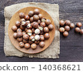Macadamia nuts on a wooden plate with burlap 140368621