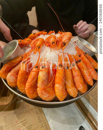 Close-up of chilled prawns or langoustines with dip, gourmet seafood dining concept. Close-up of chilled prawns or langoustines with dip, gourmet seafood dining concept. 140368698