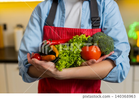 Unrecognizable woman holding fresh vegetables in home kitchen for healthy diet cooking fit lifestyle Unrecognizable woman holding fresh vegetables in home kitchen for healthy diet cooking fit lifestyle 140368963