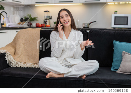 Young woman answers phone cheerful talk active friendly voice smiles laughs shares news lively chat Young woman answers phone cheerful talk active friendly voice smiles laughs shares news lively chat 140369138