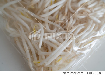 A close-up of a bag of bean sprouts in a clear plastic bag. A close-up of a bag of bean sprouts in a clear plastic bag. 140369180