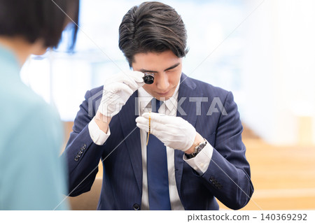 On-site appraisal of precious metals by a man. Filming assistance provided by: Denpa Gakuen Educational Foundation, Tokyo Electronics College. 140369292