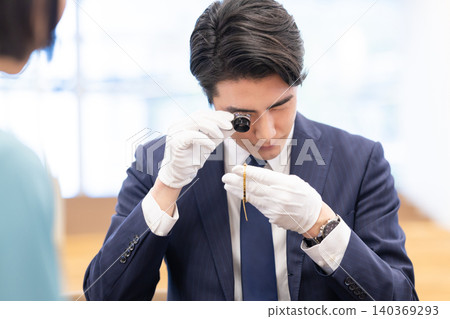 On-site appraisal of precious metals by a man. Filming assistance provided by: Denpa Gakuen Educational Foundation, Tokyo Electronics College. 140369293