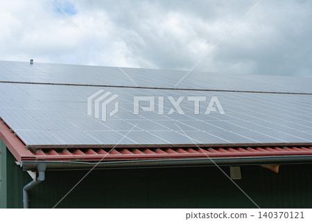Angular close-up shot of a modern building roof equipped with photovoltaic solar panels. Represents eco-friendly home improvement, renewable power generation, and carbon footprint reduction. High 140370121