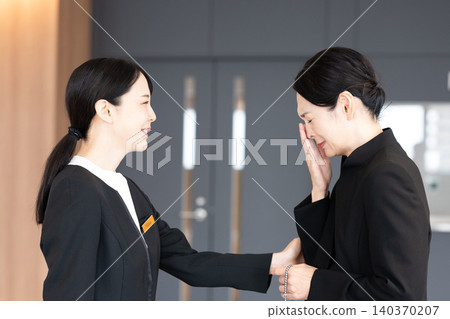 工作人員安慰悲傷的來賓。 工作人員安慰悲傷的來賓。 140370207