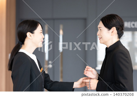Staff members offering comfort to grieving attendees. 140370208