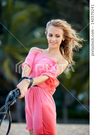 Woman in Pink Dress Outdoors Woman in Pink Dress Outdoors 140370241