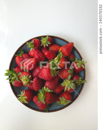 Fresh Ripe Strawberries Dark Ceramic Bowl Overhead Flat Lay White Background Fresh Ripe Strawberries Dark Ceramic Bowl Overhead Flat Lay White Background 140370582