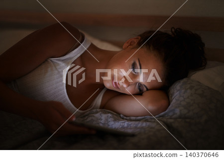 Female person, tablet and bed at night, scrolling and entertainment with tech and relaxing for peace before sleep. Woman, browsing and online for home, internet and ebook or social media 140370646