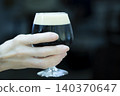 Woman holding a dark beer 140370647
