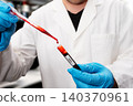 Laboratory Worker Pipetting Blood into HIV Test Tube 140370961
