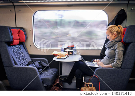 Woman, train and travel with laptop on journey or research project on commute for destination, transportation or internet. Female person, railroad and passenger in Canada for comfort, tourist or trip Woman, train and travel with laptop on journey or research project on commute for destination, transportation or internet. Female person, railroad and passenger in Canada for comfort, tourist or trip 140371413