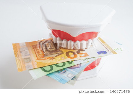 Treatment dental care cost, dental expense or fee, Euro banknote money with teeth model. Treatment dental care cost, dental expense or fee, Euro banknote money with teeth model. 140371476