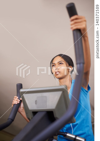 Woman, earphones and audio for cycling, bike and stationary machine for workout at club. Female person, cardio and inspirational podcast for motivation, playlist and equipment for fitness and health Woman, earphones and audio for cycling, bike and stationary machine for workout at club. Female person, cardio and inspirational podcast for motivation, playlist and equipment for fitness and health 140371589