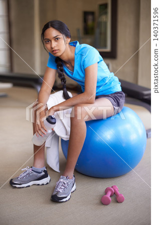 Portrait, fitness ball and woman with exercise, relax and sweaty with training and endurance. Athlete, sports and girl in a wellness center or healthy with workout and water bottle with rest or peace Portrait, fitness ball and woman with exercise, relax and sweaty with training and endurance. Athlete, sports and girl in a wellness center or healthy with workout and water bottle with rest or peace 140371596