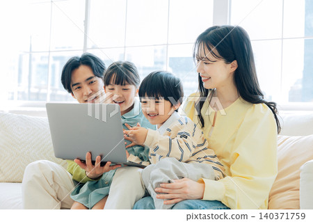 Family watching computer on the sofa Family watching computer on the sofa 140371759