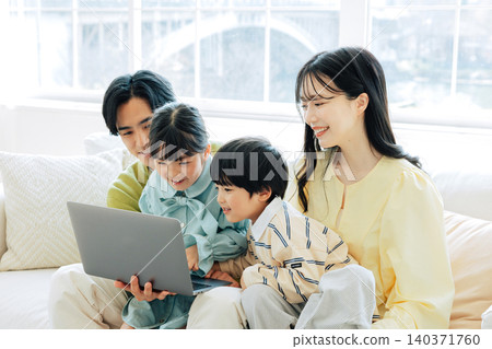 Family watching computer on the sofa Family watching computer on the sofa 140371760