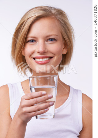 Drinking water, portrait and happy woman for wellness, nutrition and hydration in studio against white background. Detox, female person or model and healthy lifestyle for diet and weight loss. 140371826