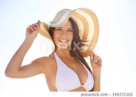 Portrait, bikini and happy woman with hat outdoor for summer, vacation or travel on blue sky mockup space. Face, swimsuit and smile of young person or tourist on adventure with wind in the Bahamas 140372102