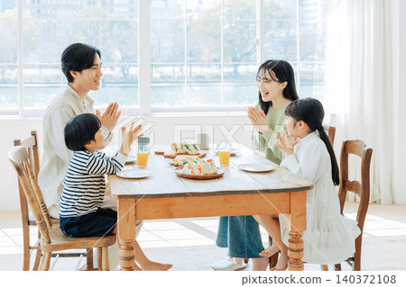 家人在吃飯前將雙手合十。 家人在吃飯前將雙手合十。 140372108