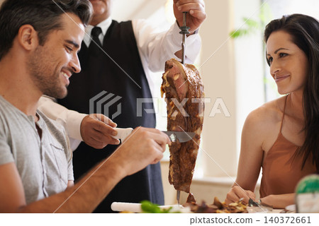 Couple, server and serving for dinner in restaurant with meat, happiness and fine dining for anniversary or honeymoon. Man, woman and employee with steak on skewer, healthy meal and table in London Couple, server and serving for dinner in restaurant with meat, happiness and fine dining for anniversary or honeymoon. Man, woman and employee with steak on skewer, healthy meal and table in London 140372661