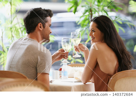 Couple, restaurant and cheers for anniversary celebration, fine dining and bonding at bistro. People, love and romance at cafe or toasting with alcohol or wine glasses, marriage milestone and happy 140372684