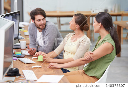 Creative, coworking space and man with women at desk for conversation, brainstorming and digital marketing. Computer, office and teamwork at online advertising agency with discussion for planning. Creative, coworking space and man with women at desk for conversation, brainstorming and digital marketing. Computer, office and teamwork at online advertising agency with discussion for planning. 140372807
