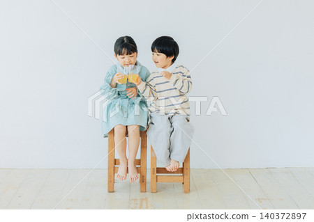 A child sitting in a chair and drinking juice A child sitting in a chair and drinking juice 140372897