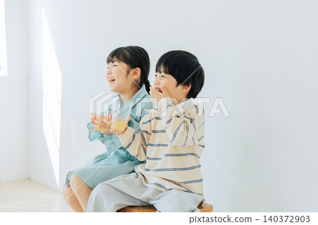 A child sitting in a chair and drinking juice A child sitting in a chair and drinking juice 140372903