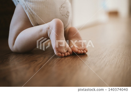 Baby Crawling on Wooden Floor Close-Up Baby Crawling on Wooden Floor Close-Up 140374040