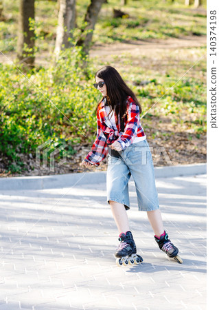 Young woman roller skating in a park during spring enjoying a sunny day Young woman roller skating in a park during spring enjoying a sunny day 140374198