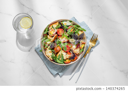 Tuscan panzanella salad with tomatoes, red onion, arugula, basil, cheese and bread in a bowl Tuscan panzanella salad with tomatoes, red onion, arugula, basil, cheese and bread in a bowl 140374265