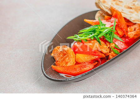 Stir Fried Meat with Bell Pepper and Flatbread on Black Plate 140374364