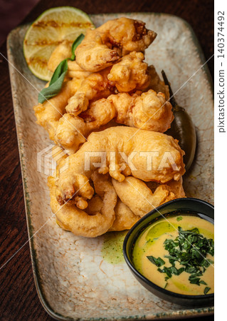 Crispy fried calamari rings with creamy dipping sauce in restaurant style presentation Crispy fried calamari rings with creamy dipping sauce in restaurant style presentation 140374492