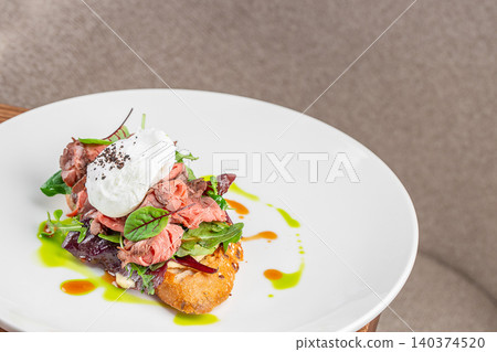 Open sandwich with roast beef poached egg and fresh greens on white plate with copy space Open sandwich with roast beef poached egg and fresh greens on white plate with copy space 140374520