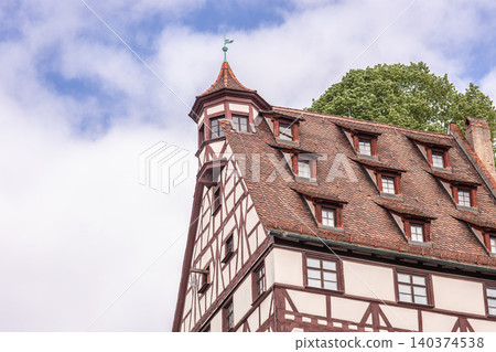 Traditional half timbered historic building roof against cloudy sky in Europe Traditional half timbered historic building roof against cloudy sky in Europe 140374538