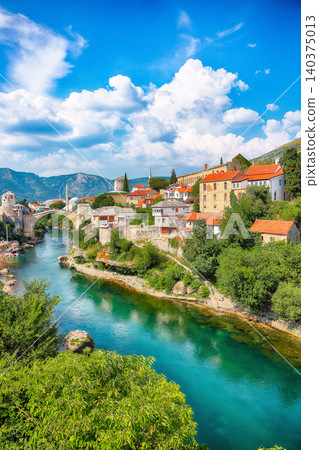 Amazing Skyline of Mostar with the Mostar Bridge, houses and minarets, during sunny day Amazing Skyline of Mostar with the Mostar Bridge, houses and minarets, during sunny day 140375013