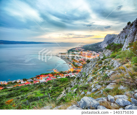 Amazing aerial panoramic view of Cetina river, mountains and Old town Omis at sunset. Amazing aerial panoramic view of Cetina river, mountains and Old town Omis at sunset. 140375030