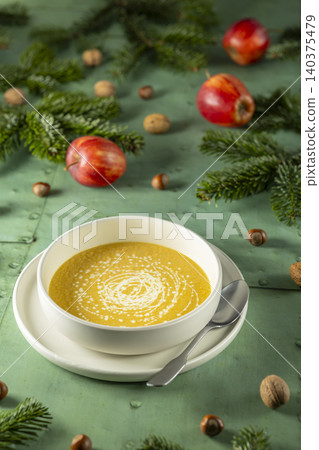 Creamy pumpkin soup on a rustic Christmas table setting Creamy pumpkin soup on a rustic Christmas table setting 140375479