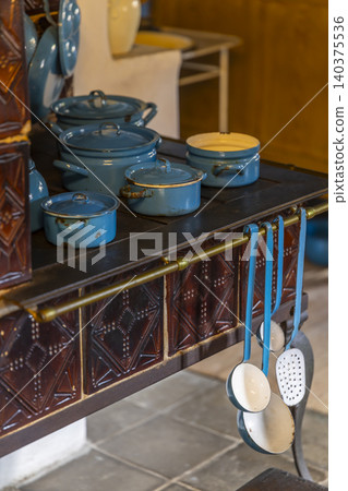 Traditional tiled stove in old kitchen with blue enamelware in Prerov nad Labem 140375536