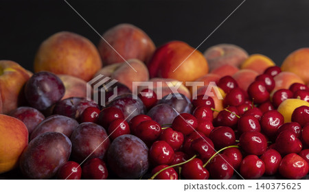 Fresh stone fruit assortment including peaches, plums, and cherries 140375625