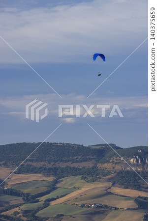 Paraglider flying high above Creissels landscape Paraglider flying high above Creissels landscape 140375659