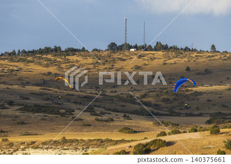 Paragliders flying over dry landscape in Creissels Paragliders flying over dry landscape in Creissels 140375661