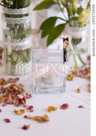 Wedding table centerpiece decorating with candles and rose petals 140375689