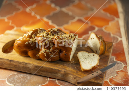 Homemade braided challah bread with almond flakes 140375693