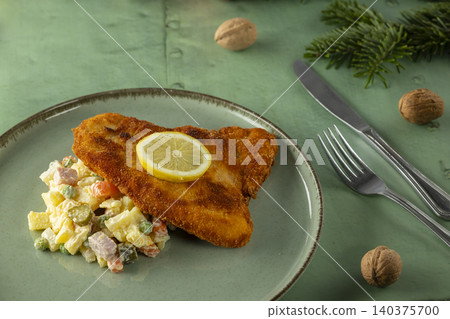 Crispy schnitzel with traditional potato salad and lemon 140375700