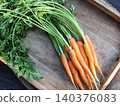 Freshly picked carrots with green tops on a wooden board 140376083
